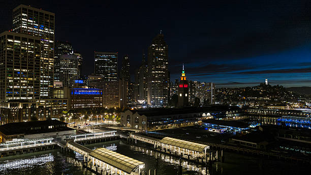 istock Waterfront structures, piers, and buildings illuminated along San Francisco Bay at night. 2224917762