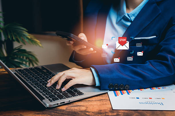 istock Businessman Working with Smartphone and Laptop Surrounded by Spam Emails in Modern Office Environment 2224918924