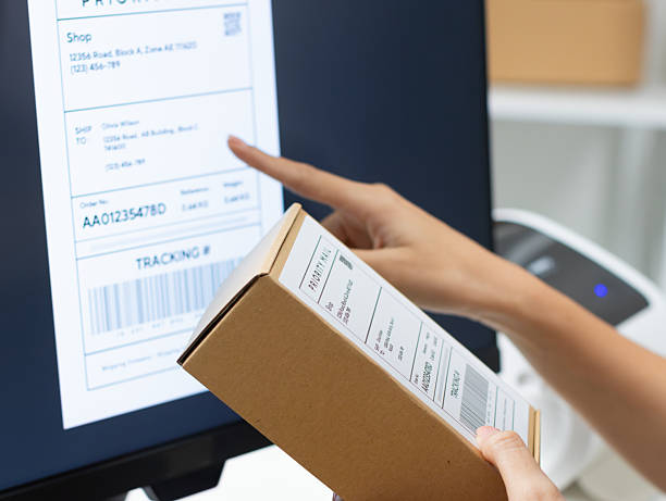 Asian Female Small Business owner Prepare Parcel for Delivery checking information on computer before shipping.