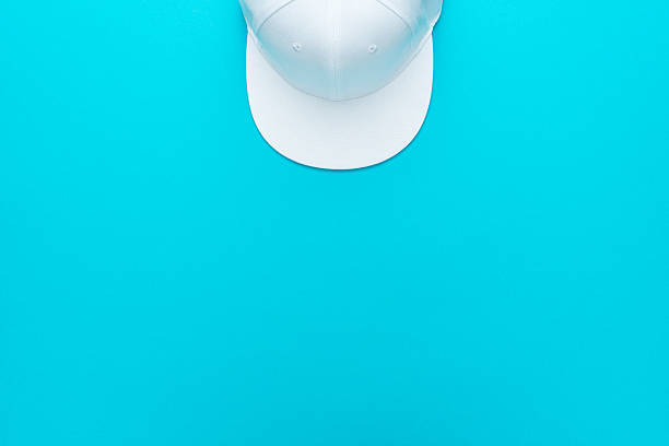 istock Top view of white baseball cap over torquoise blue background with copy space 2224925318