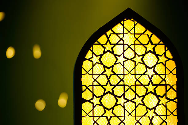islam lantern with bokeh light against green background.