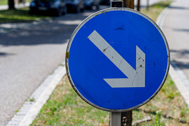 Close-up of blue and white one way road sign with arrow at Swiss City of Zürich on a sunny spring day. Photo taken May 1st, 2025, Zurich, Switzerland.