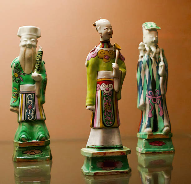 istock Traditional Chinese figurines crafted from porcelain displayed on a reflective surface showcasing intricate designs and bright colors 2224951126
