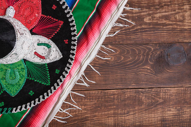 Serape and Mexican hat on wooden table. Mexican background.