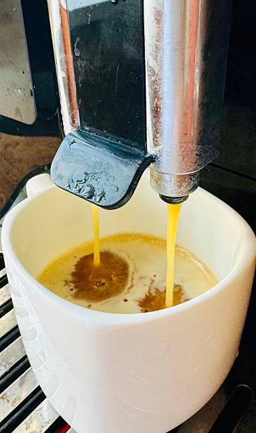 istock Espresso pouring from a coffee machine into a white cup 2224952186