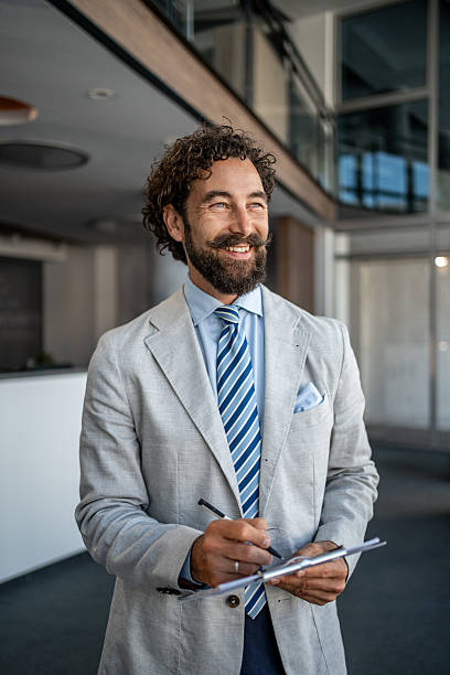 istock Smiling businessman taking notes in modern office building 2224952605