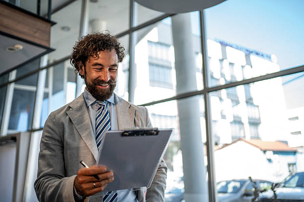 istock Happy businessman reading documents on clipboard in office building 2224952681