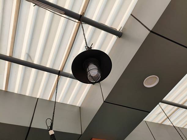 istock Hanging black lamp with a clear bulb suspended from a ceiling. 2224954435