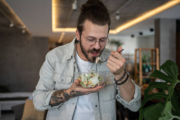 istock Young man enjoying a healthy salad in a modern restaurant 2224954918