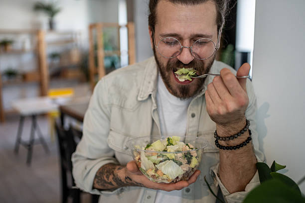 istock Young man enjoying a healthy salad at home 2224954942