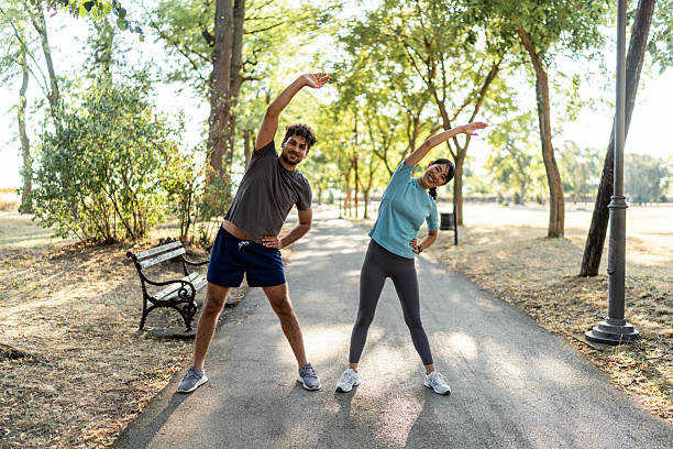 istock Young couple stretching together before exercising in a park 2224956131