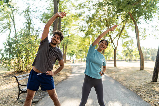 istock Young couple stretching together in a sunny park 2224956151
