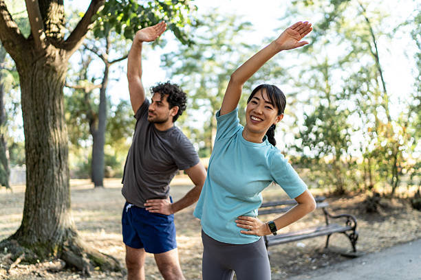istock Young couple stretching together in the park before exercising 2224956172