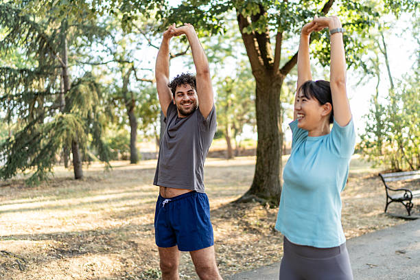 istock Young couple stretching arms together before exercising in park 2224956179