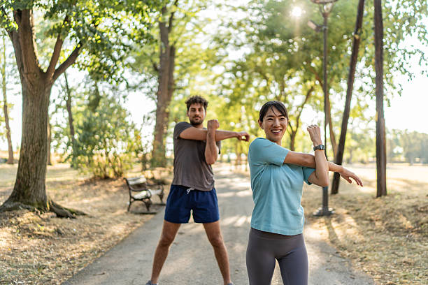 istock Young couple stretching arms together before exercising in park 2224956195