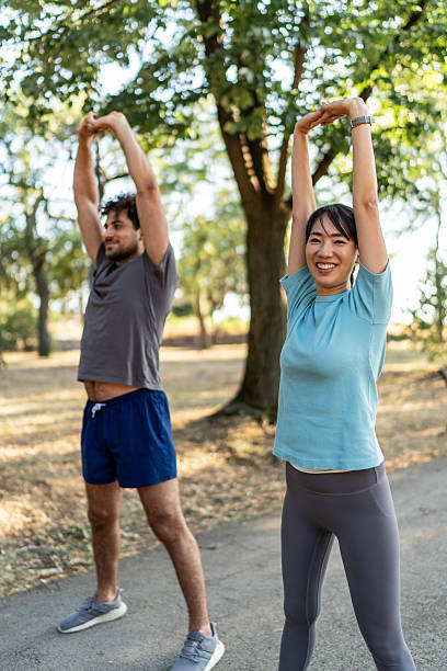 istock Young couple stretching arms in a park before exercising 2224956199