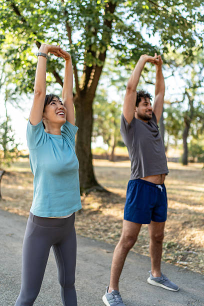 istock Young couple stretching arms in the park before exercising 2224956202