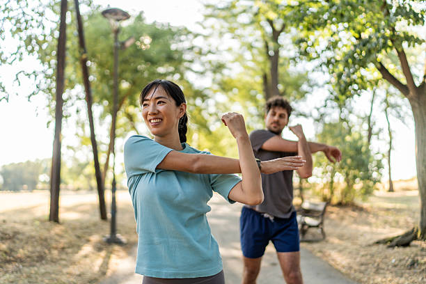 istock Young couple stretching arms together before exercising in park 2224956245