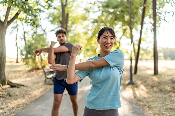 istock Young couple stretching arms before exercising in park 2224956252