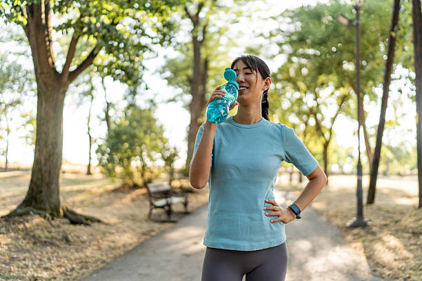 istock Young sportswoman drinking water in a park during a workout 2224956384