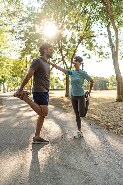 istock Young couple stretching legs together before running in a park 2224956521