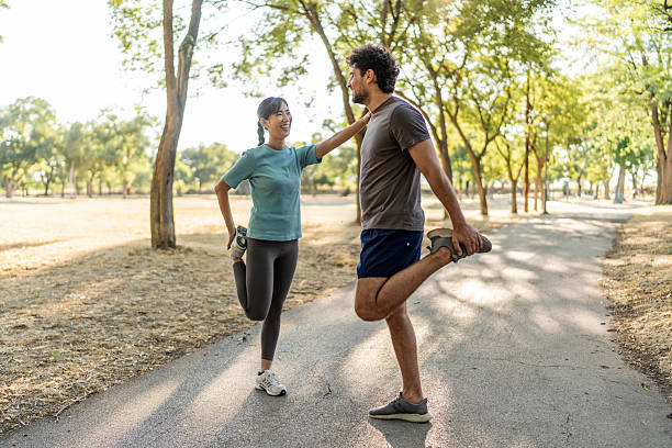 istock Young couple stretching legs together before running in a park 2224956560