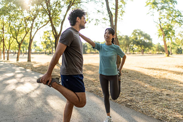 istock Young couple stretching legs together before running in a park 2224956563