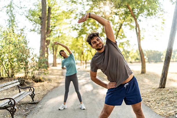 istock Young couple stretching together before exercising in a park 2224957101