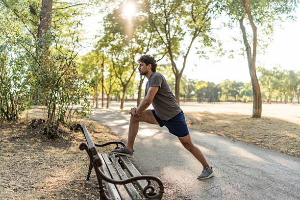 istock Young man stretching legs in a park before running 2224957253