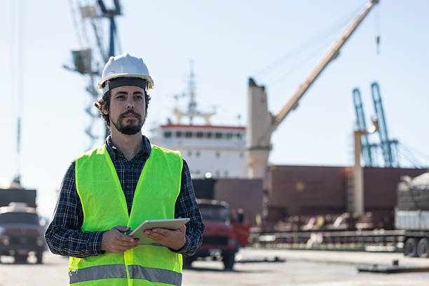 istock Port worker with tablet at cargo port with ship 2224960722