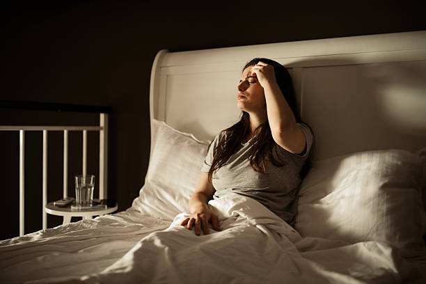 istock A woman lying in bed, feeling unwell and sick. 2224966986