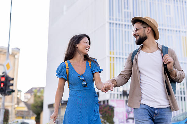 istock Couple walking happily, holding hands in a bright urban scene. 2224967323