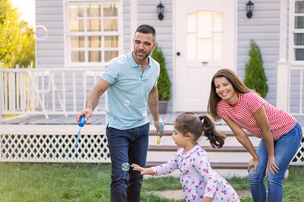 istock Young family playing in the garden with bubbles 2224967471