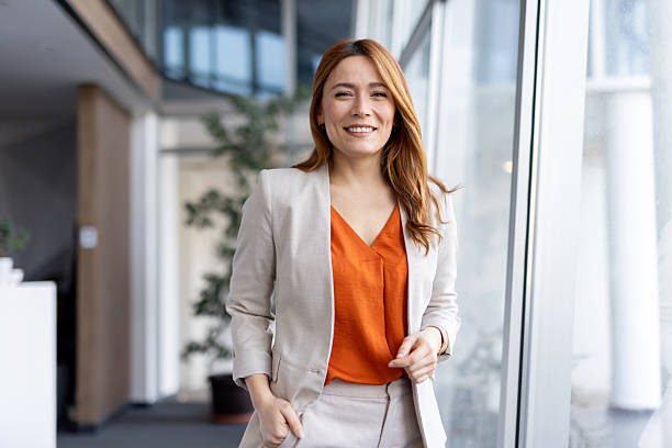 istock Cheerful woman strides along bright office windows 2224971847