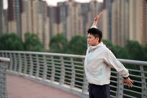 Asian man stretching and getting ready to go for run
