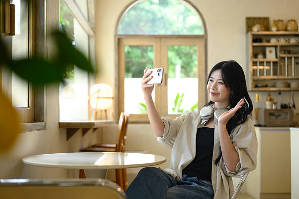 istock Young woman taking a selfie while sitting at a stylish cafe 2224991038