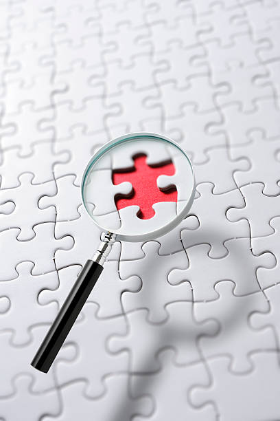 istock Magnifying glass floating in mid-air over the blank jigsaw puzzle 2224995962