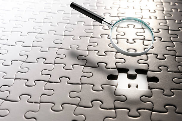istock Magnifying glass floating in mid-air over the blank jigsaw puzzle 2224995966