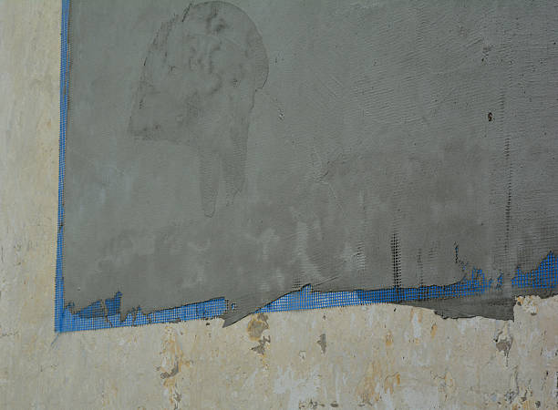 istock Cross-section view on a house external plastering layers.  Installing a reinforcing mesh and rendering to the external wall during repair and renovate house facade. 2224996651