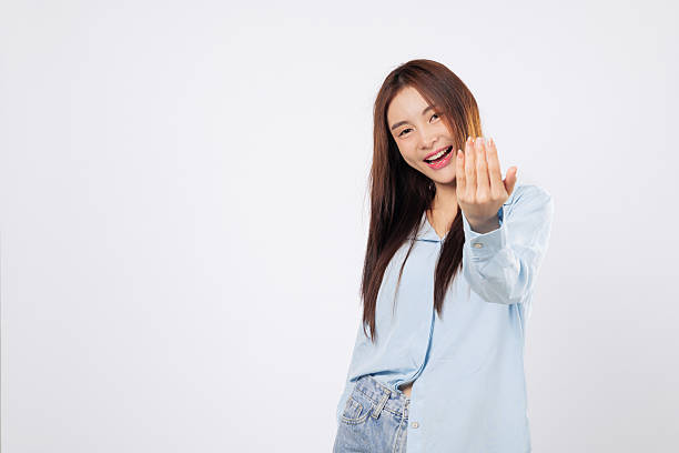 istock Woman gestures come here with open palm, second woman inviting with cheerful face 2224998064