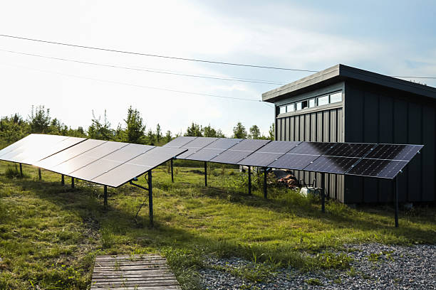 istock Solar panel installations beside a modern utility building in a green field, generating renewable energy on a sunny day 2224998204