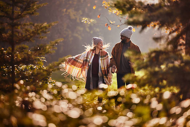 Carefree couple having fun while running in autumn day.