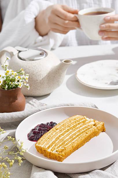 istock Medovik layer cake bright overhead with tea, summer picnic mood and artisan ceramic tableware 2225000332