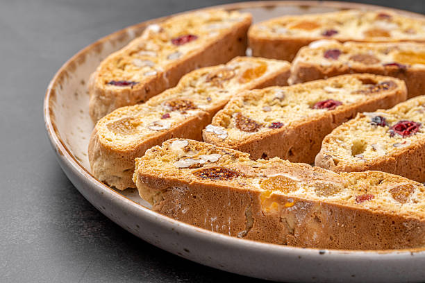 istock Italian Almond Biscotti biscuits in a rustic home made pottery bowl. Studded with almonds and cranberries, these twice-baked treats are aromatic and inviting. Ideal. 2225000602