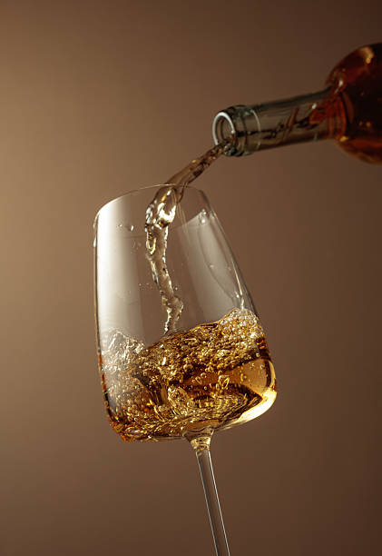 istock Pouring white wine from a bottle into a glass. 2225001124