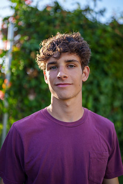 istock Young man with curly hair posing in a garden 2225002160