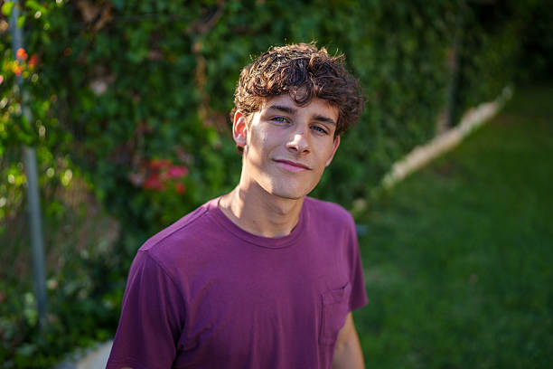 istock Young man with curly hair smiling in a garden 2225002164
