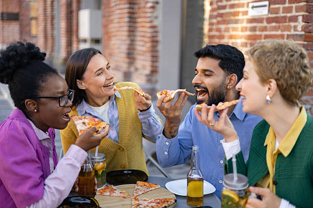 istock Friends Enjoying Pizza Outdoors 2225007897
