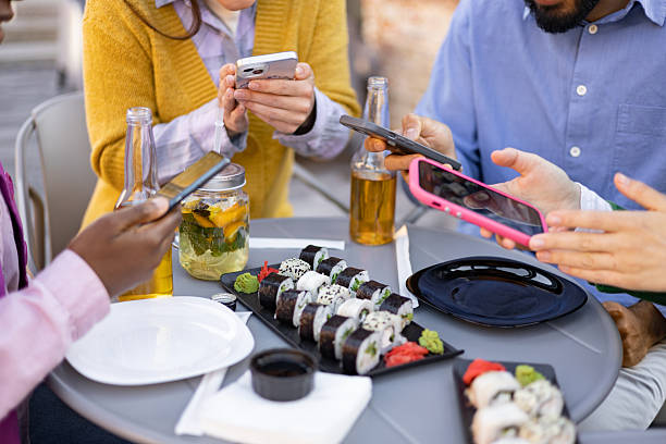istock Friends Enjoying Sushi and Tech 2225007909