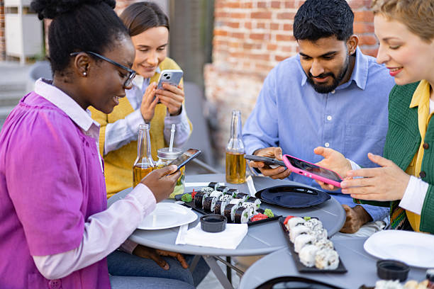 istock Friends Enjoying Sushi and Smartphones 2225007911
